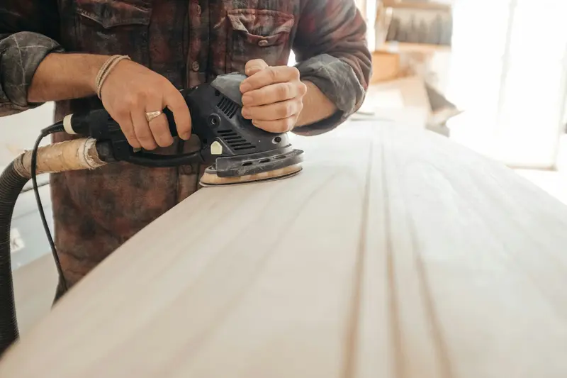 Sanding an oak floor by hand at the edge with an orbital sander